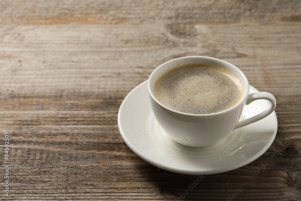 Tasty coffee in cup on wooden table, closeup. Space for text Tasty coffee in cup on wooden table, closeup. Space for text