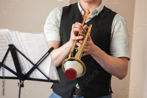Photography Trumpet with straight mute is in trumpeter hands. Close up view