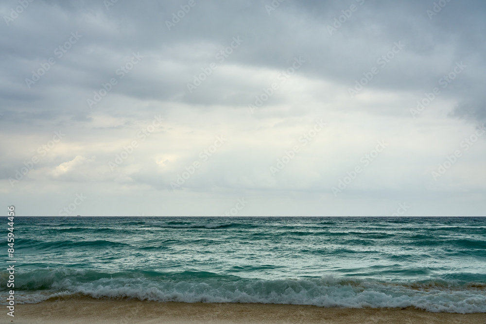 Waves and foam on a tropical sandy beach with clouds. Waves and foam on a tropical sandy beach with clouds.
