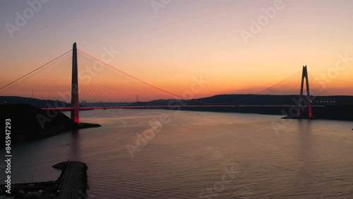 Bosphorus Istanbul landscape on sunset. Aerial of Yavuz Sultan Selim Bridge with lights and red reflections in the sea. Bridge crosses Bosporus Strait between Garipçe village on European side and Poyr photo