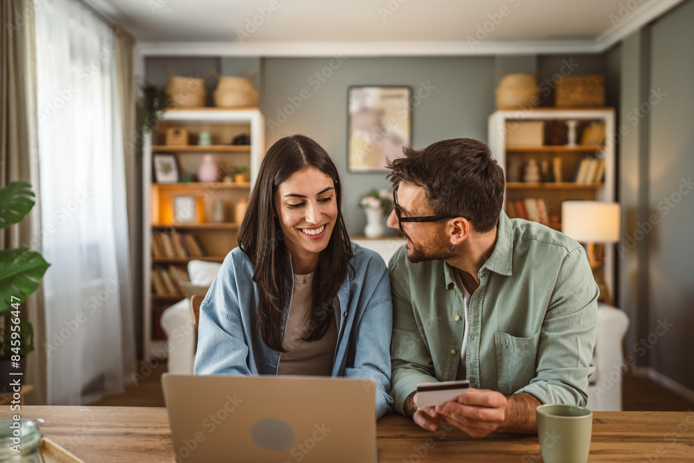 Boyfriend and girlfriend buy online on laptop with credit card at home Boyfriend and girlfriend buy online on laptop with credit card at home