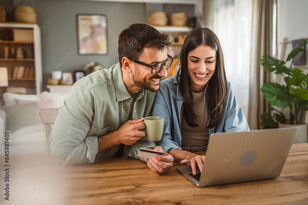 Boyfriend and girlfriend buy online on laptop with credit card at home Boyfriend and girlfriend buy online on laptop with credit card at home