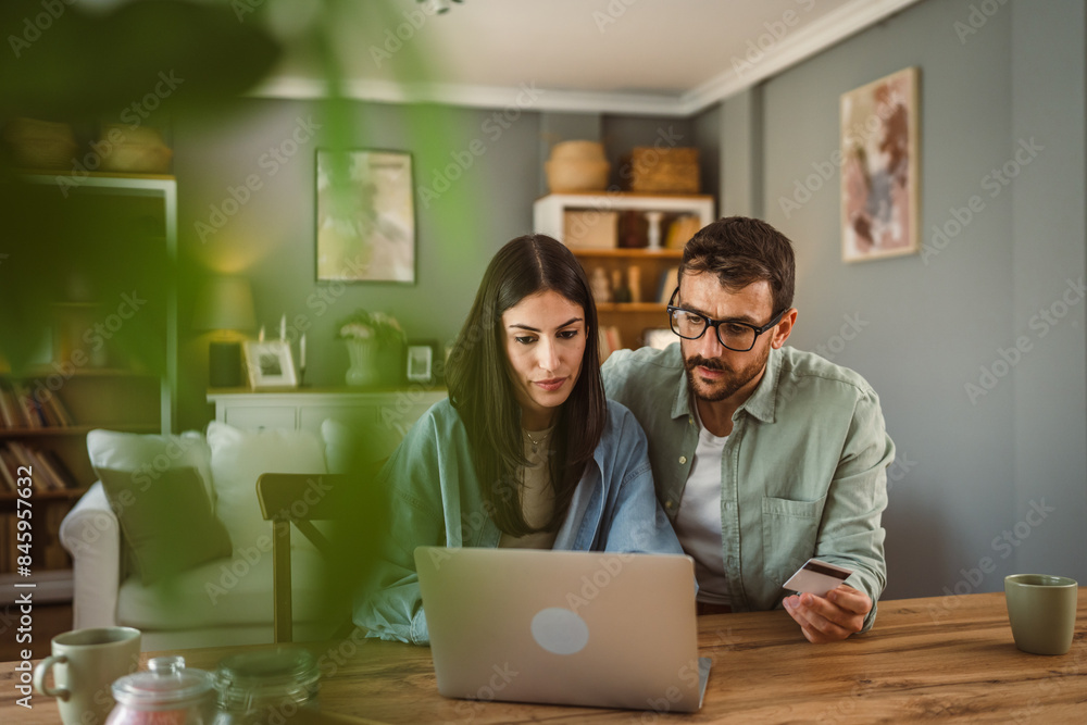 Boyfriend and girlfriend buy online on laptop with credit card at home Boyfriend and girlfriend buy online on laptop with credit card at home