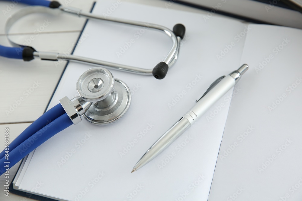 One new medical stethoscope on white wooden table, closeup One new medical stethoscope on white wooden table, closeup
