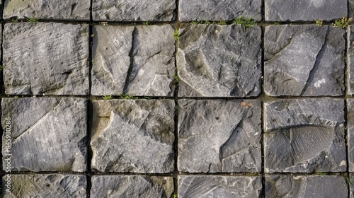 Texture of gray rectangular paving slabs in close up depicting unfinished park pathway arrangement