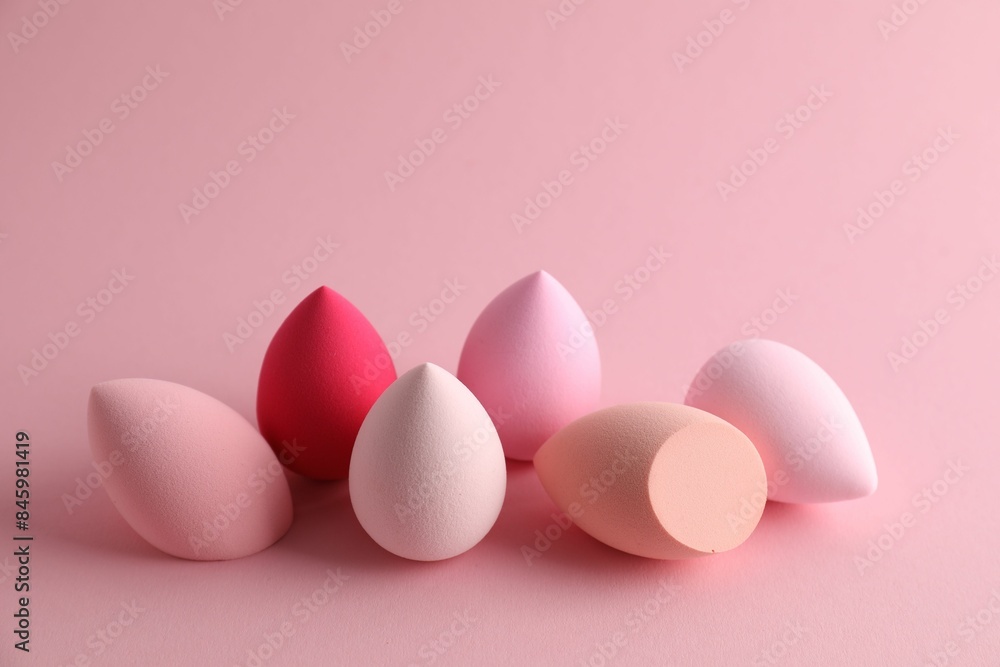 Many colorful makeup sponges on pink background Many colorful makeup sponges on pink background