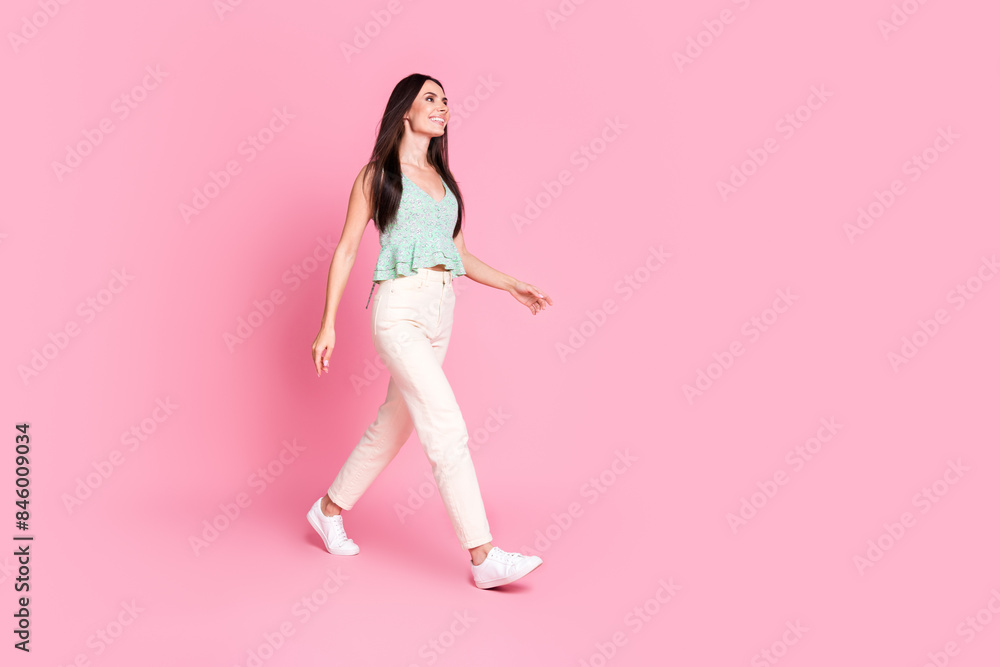 Full length photo of cheerful lovely cute woman wear trendy clothes looking empty space isolated on pink color background Full length photo of cheerful lovely cute woman wear trendy clothes looking empty space isolated on pink color background