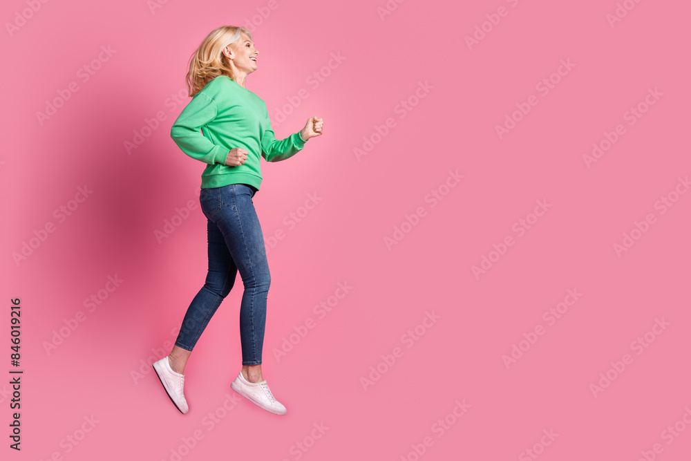 Full body photo of attractive retired woman running shopping dressed stylish green clothes isolated on pink color background Full body photo of attractive retired woman running shopping dressed stylish green clothes isolated on pink color background