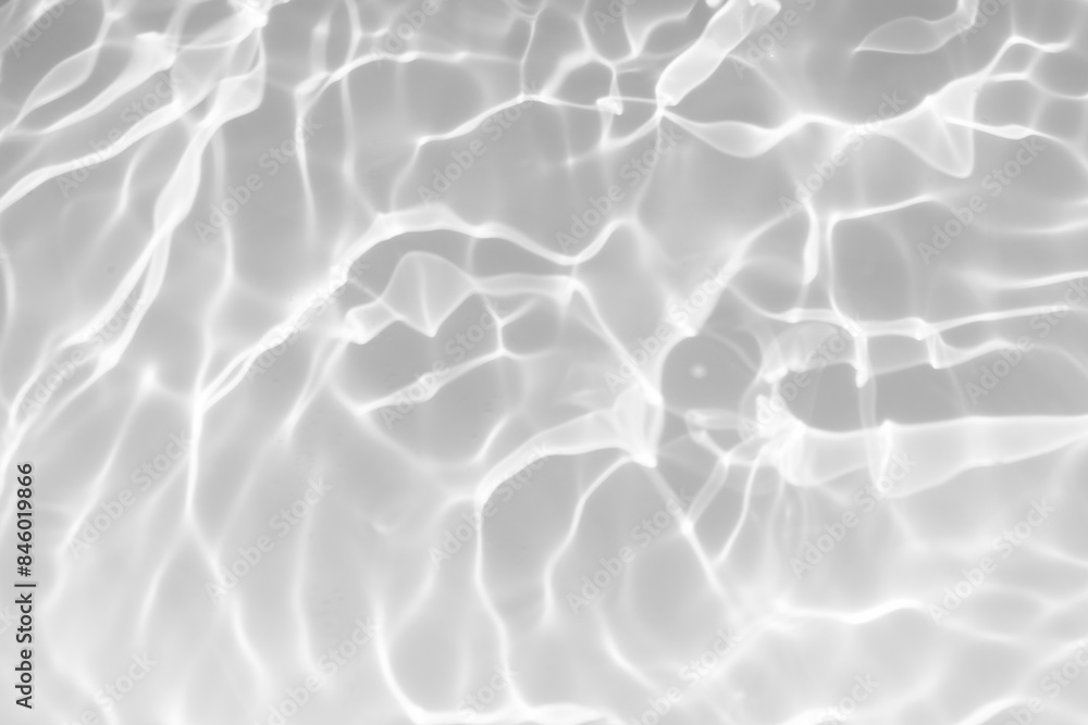 Obraz premium White water with ripples on the surface. Defocus blurred transparent white colored clear calm water surface texture with splashes and bubbles. Water waves with shining pattern texture background.