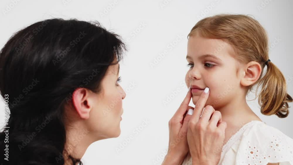 Family relationships between mother and daughter. Sensual mother with her little daughter on a light studio background. Tender moment, family support. Family relationships between mother and daughter. Sensual mother with her little daughter on a light studio background. Tender moment, family support.