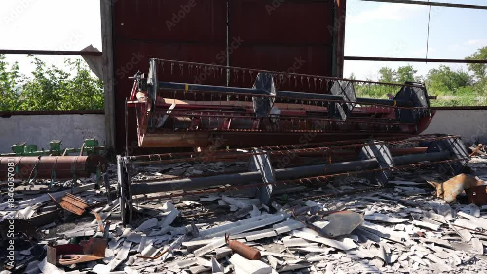 Damaged agricultural equipment on farm. Farm ruins with scattered equipment and debris. The concept of war, destruction, oblivion Damaged agricultural equipment on farm. Farm ruins with scattered equipment and debris. The concept of war, destruction, oblivion