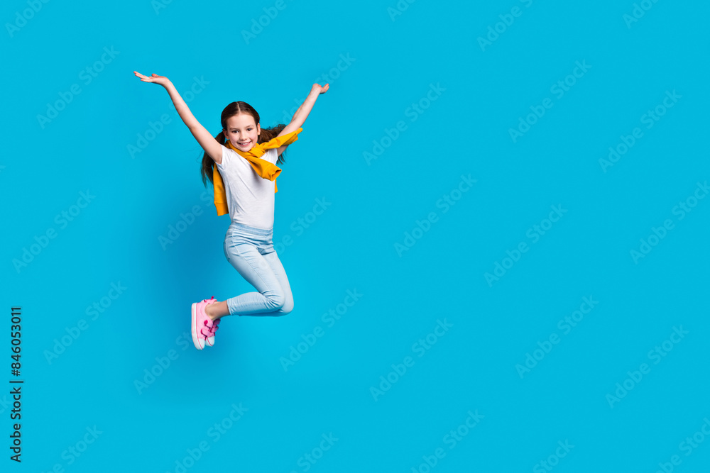 Obraz premium Photo of sweet lovely small girl wear tied pullover jumping high empty space isolated blue color background