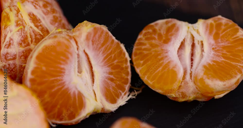 peeled , orange tangerines on the table in close-up, a large number of orange citrus fruits on a black slate surface peeled , orange tangerines on the table in close-up, a large number of orange citrus fruits on a black slate surface