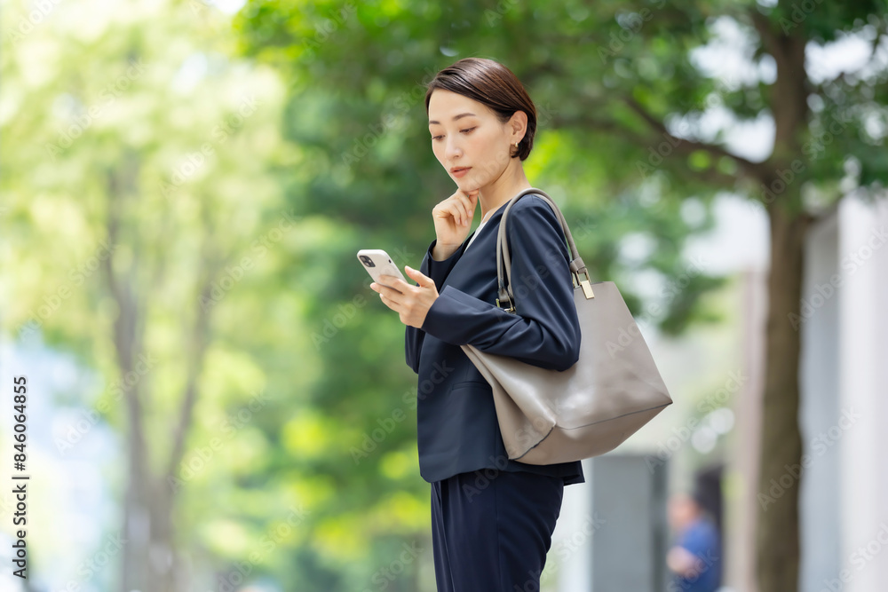 スマートフォンを持つ悩むビジネス女性