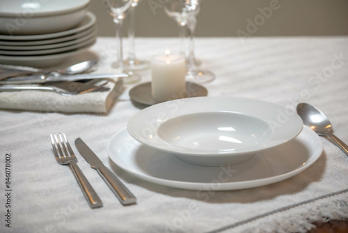 Luxurious table setting with white plates  crystal glasses and fine cutlery