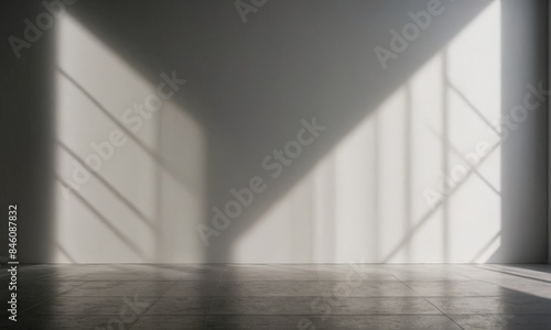 Empty room with geometric shadows on the wall and floor.