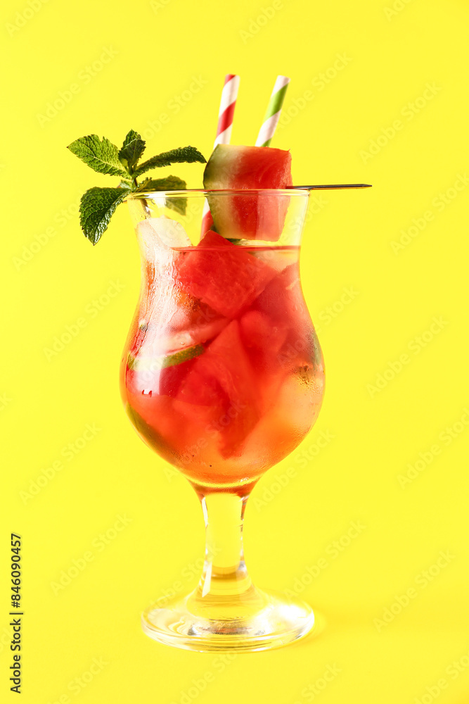 Glass of fresh watermelon lemonade with lime and mint on yellow background Glass of fresh watermelon lemonade with lime and mint on yellow background
