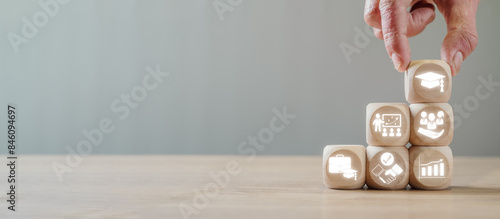 Wooden blocks with icons symbolizing education, training, and career growth, perfect for illustrating professional development and trainee concepts. photo