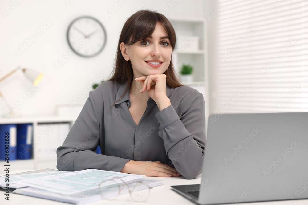 Portrait of smiling secretary at table in office Portrait of smiling secretary at table in office