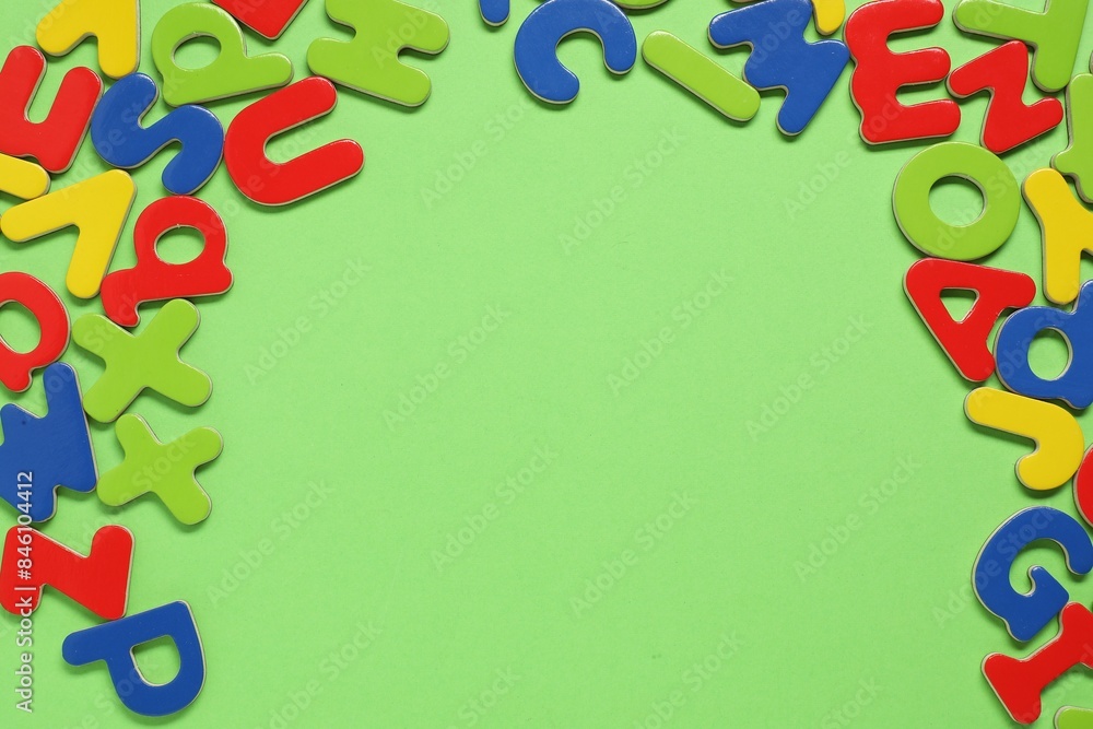 Learning alphabet. Magnetic letters on green background, flat lay. Space for text Learning alphabet. Magnetic letters on green background, flat lay. Space for text