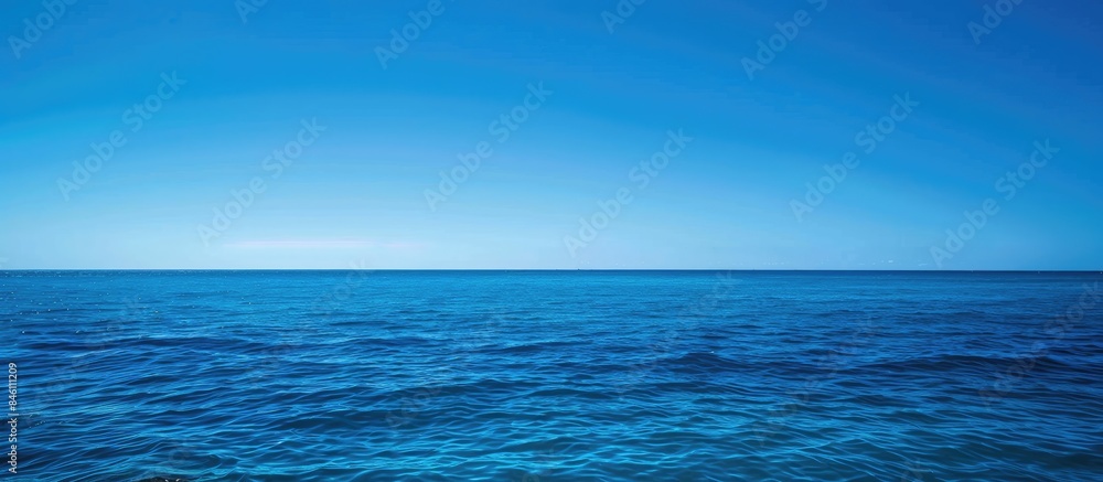 Obraz premium Vivid blue ocean under a clear sky with room for text.