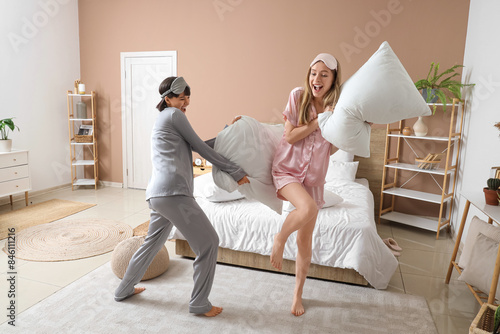Young women fighting pillow...