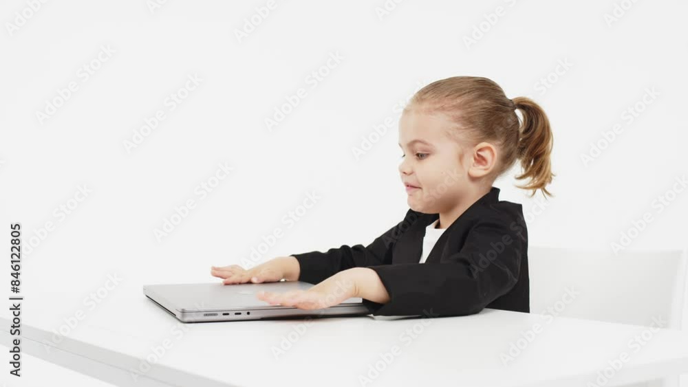 Little business girl child working or studying on a light background with a laptop. Modern online education, business and technology. Little business girl child working or studying on a light background with a laptop. Modern online education, business and technology.