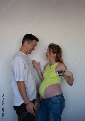Expecting parents eagerly await their baby's arrival, holding the first ultrasound