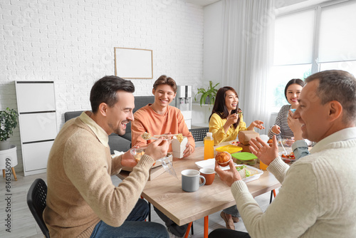 Group of business people having lunch in office kitchen