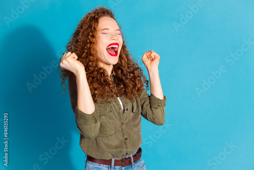 Portrait of pretty young woman raise fists empty space wear khaki shirt isolated on turquoise color background