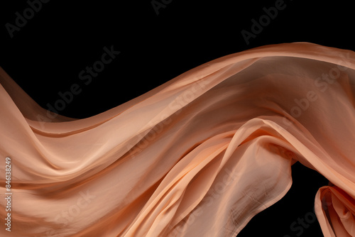 Orange Organza fabric flying in curve shape, Piece of textile Orange Organza fabric throw fall in air. Black background isolated, dark shading environment