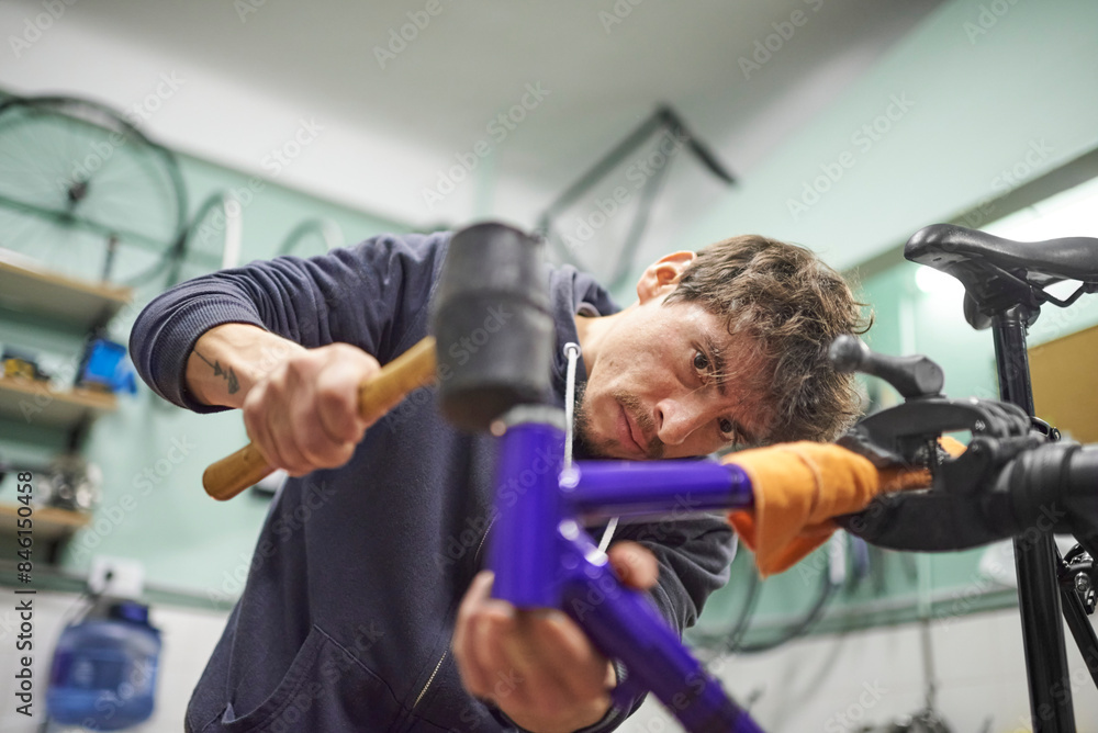 Fototapeta premium Hispanic man assembling a bicycle in his bike shop during maintenance service