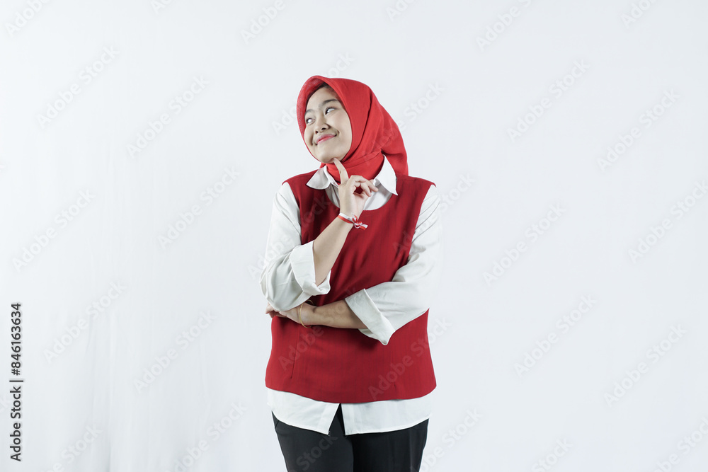 Asian hijab woman in looks happy in Indonesian independence day outfit. the woman raised her hand and pointed to the upper side of the side Asian hijab woman in looks happy in Indonesian independence day outfit. the woman raised her hand and pointed to the upper side of the side