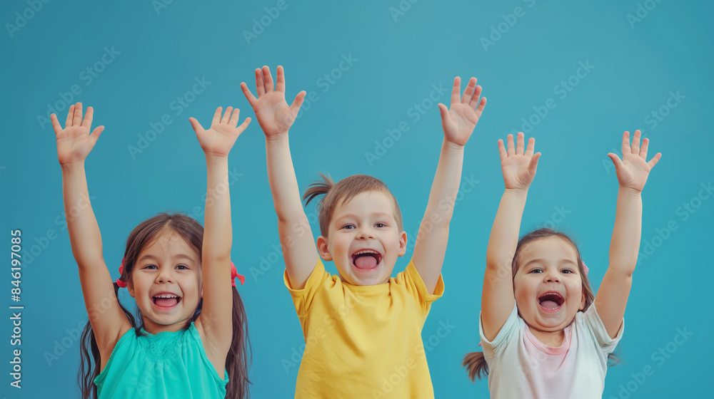 Group of children raising their hands up and smiling, ready for your text, logo or symbols.. Isolated on blue background Group of children raising their hands up and smiling, ready for your text, logo or symbols.. Isolated on blue background