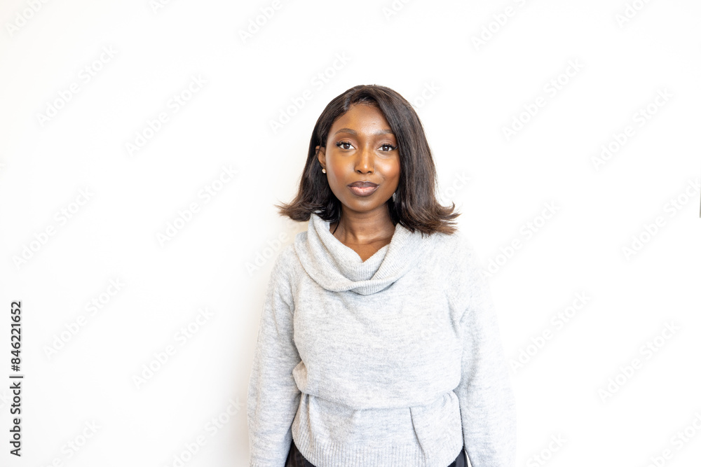 Confident professional woman in grey sweater and black pants, exuding elegance and style on white background