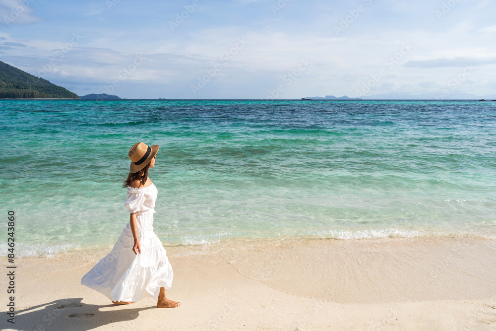 Young woman traveler relaxing and enjoying at beautiful tropical white sand beach with wave foam and transparent sea, Summer vacation and Travel concept Young woman traveler relaxing and enjoying at beautiful tropical white sand beach with wave foam and transparent sea, Summer vacation and Travel concept
