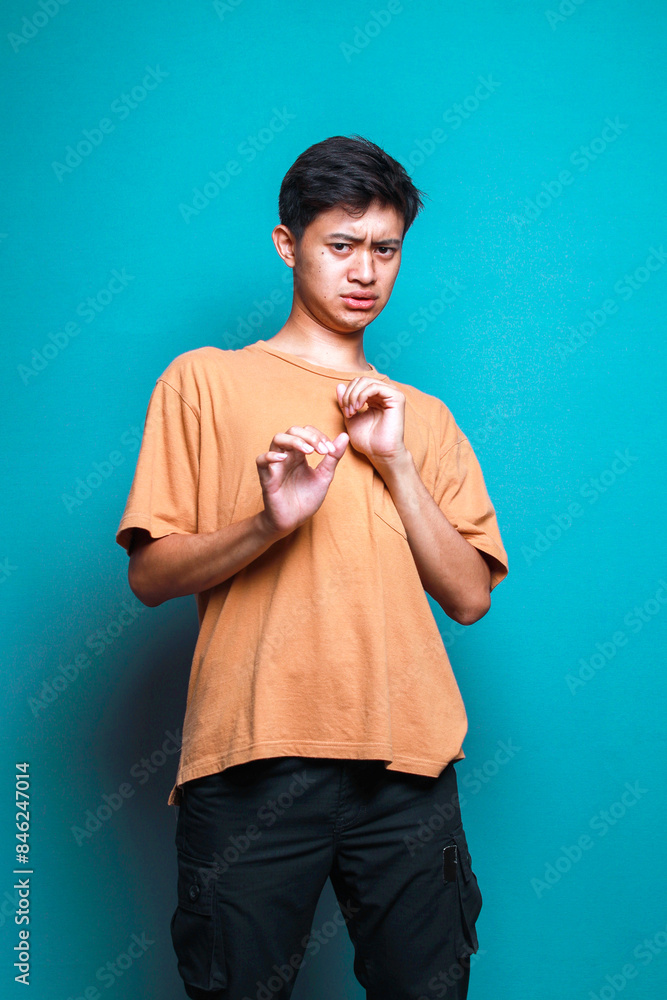 Fototapeta premium Young Asian man feeling afraid isolated over blue background