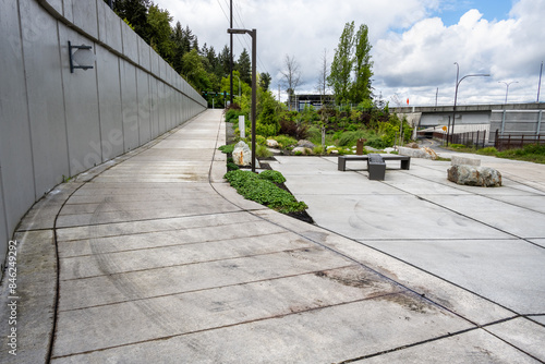 Mountains to Sound Greenway trail at Eastgate next to the highway, I90, cement urban recreation trail at a switchback turn with benches for rest
 photo