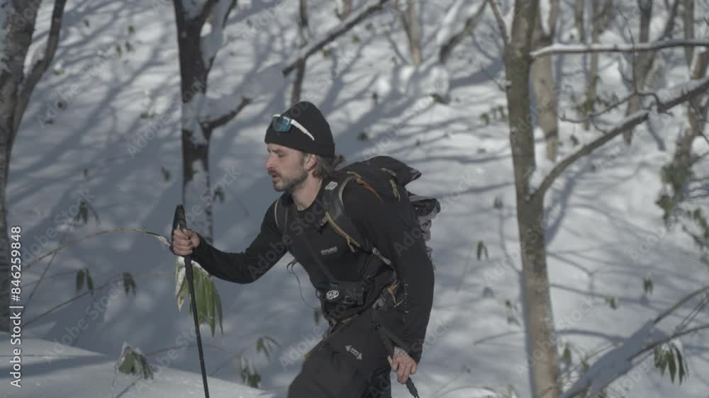 A man hiking with a splitboard in snowy Hokkaido, Japan during winter A man hiking with a splitboard in snowy Hokkaido, Japan during winter