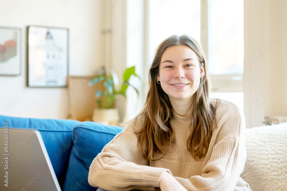 Smiling woman looks at the camera and working at a computer. Happy female occupation.