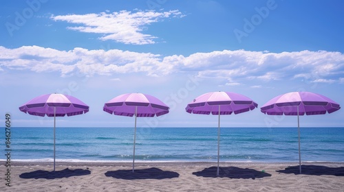 Purple beach umbrellas in a tranquil setting by the sea during summer holidays Beach umbrellas remain closed with few tourists around