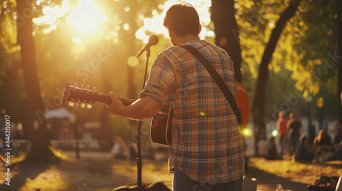 Fototapeta Naklejka Na Ścianę i Meble -  Young man playing guitar, live music in the park Stunt show or outdoor fun in the park