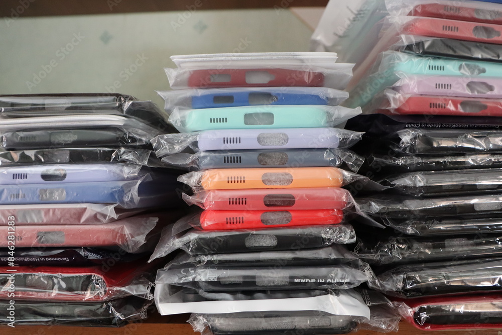 An array of smartphone cases in a variety of colors and designs neatly stacked for sale in a store An array of smartphone cases in a variety of colors and designs neatly stacked for sale in a store