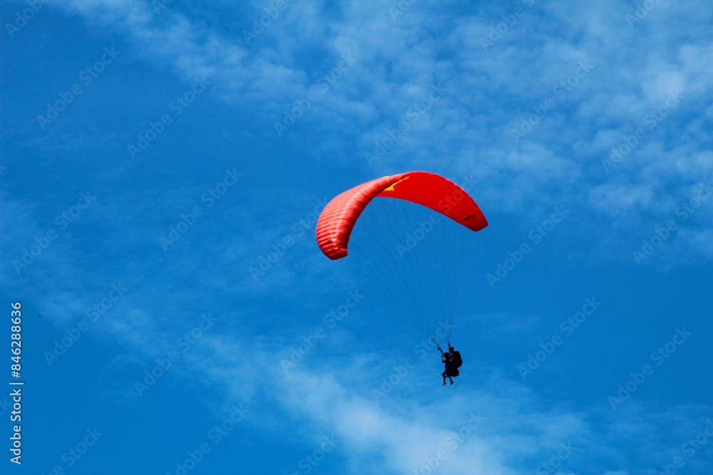 Photograph of a paraglider soaring against a clear blue sky. Captures the thrill and freedom of paragliding Photograph of a paraglider soaring against a clear blue sky. Captures the thrill and freedom of paragliding