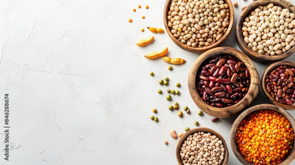 Assorted varieties of dried beans and legumes in wooden bowls on a white table Top view Plant based sources of protein for vegans with space for text Assorted varieties of dried beans and legumes in wooden bowls on a white table Top view Plant based sources of protein for vegans with space for text