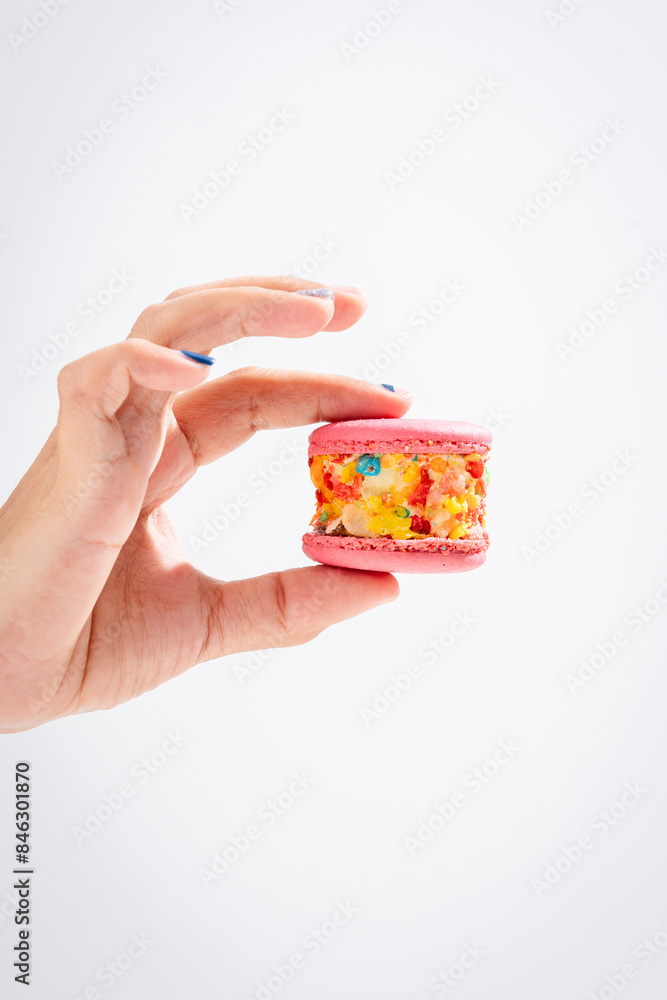 Beautiful female hands with trendy pink macaroon cake. Beautiful female hands with trendy pink macaroon cake.