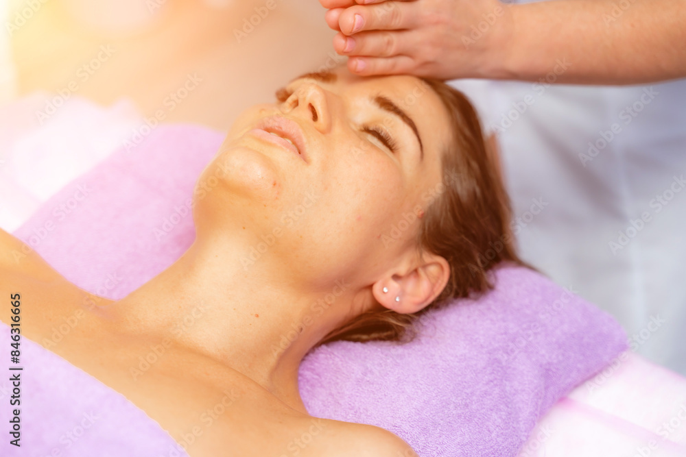 Relaxing massage. European woman getting facial massage in spa salon, side view Relaxing massage. European woman getting facial massage in spa salon, side view
