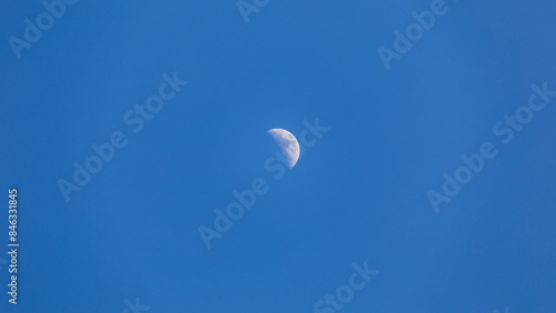 Half moon in blue sky, day moon, daytime moon in clear air