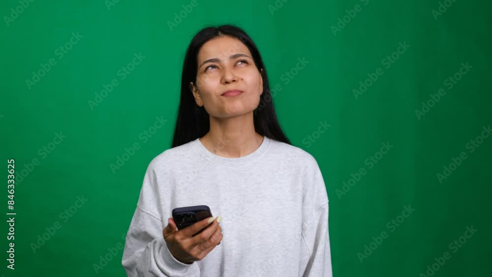 Young woman. Using mobile phone and think looking aside up Young woman. Using mobile phone and think looking aside up
