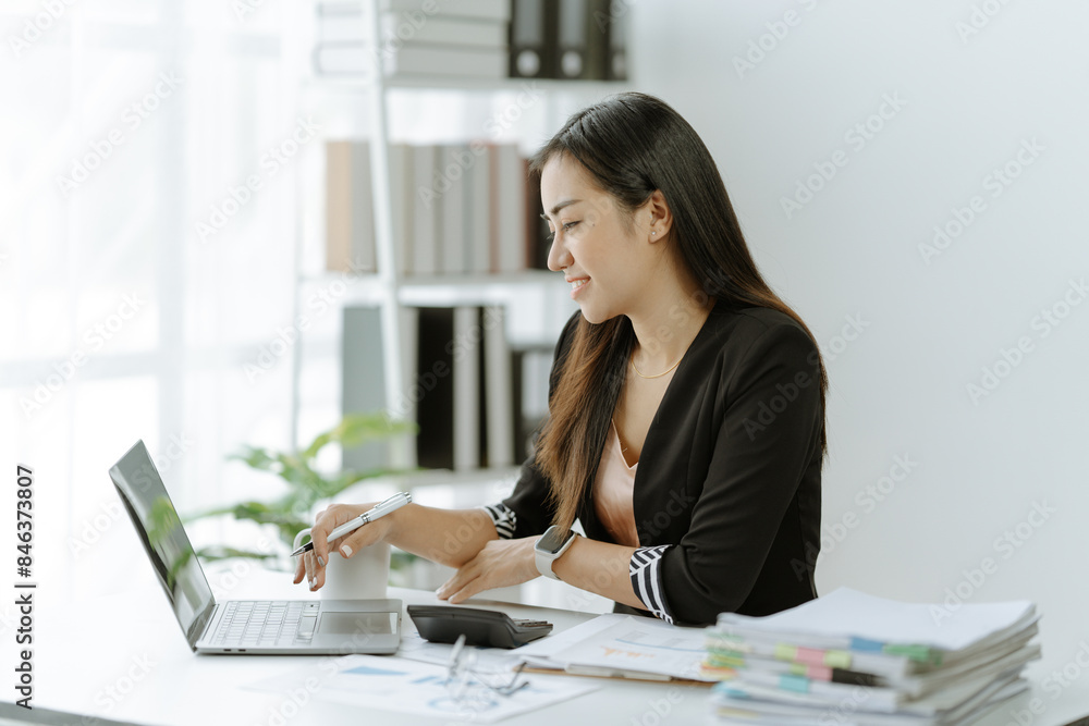 Asian Businesswoman Using laptop computer and working at office with calculator document on desk, doing planning analyzing the financial report, Asian Businesswoman Using laptop computer and working at office with calculator document on desk, doing planning analyzing the financial report,